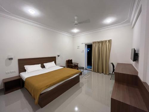 een slaapkamer met een bed, een bureau en een televisie bij Morjim Sunset Guesthouse - 300 meter to Morjim Beach in Morjim