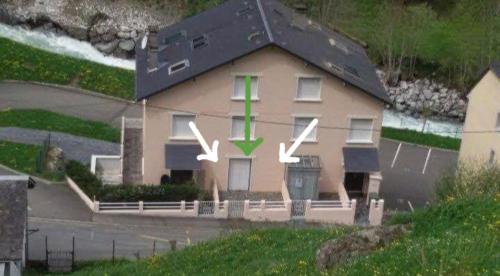 ein Haus mit einem grünen Kreuz darauf in der Unterkunft CAUTERETS Appartement F 2 vue sur montagne in Cauterets