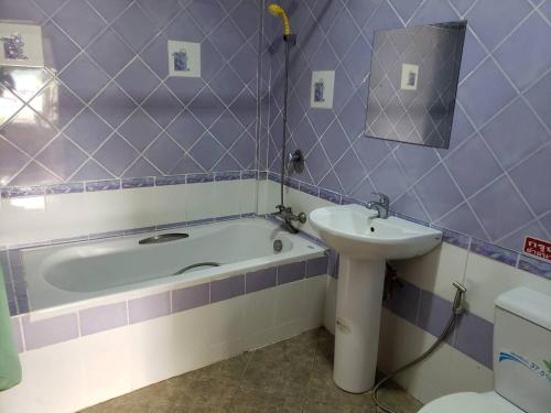 ein Badezimmer mit einer Badewanne, einem Waschbecken und einem WC in der Unterkunft Phontong Garden Resort in Kalasin