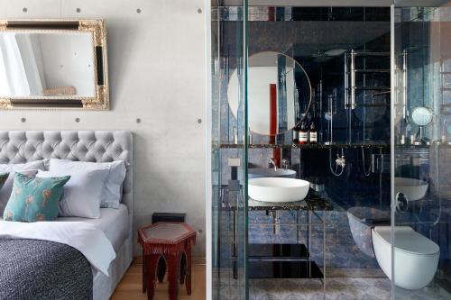 um quarto com uma cama, um lavatório e um espelho em Ola Foundation Residence em Riga