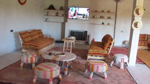 a living room with a couch and chairs and a tv at Family Village Marrakech in Marrakesh