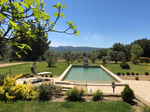 una piscina en un jardín con un parque en L'AMANDERAIE PISCINE PRIVEE à côté de LOURMARIN LUBERON, en Cadenet