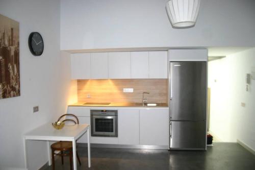 アルメリアにあるAPARTAMENTO EXCLUSIVO EN EL CASCO HISTORICOのキッチン(ステンレス製の冷蔵庫、テーブル付)