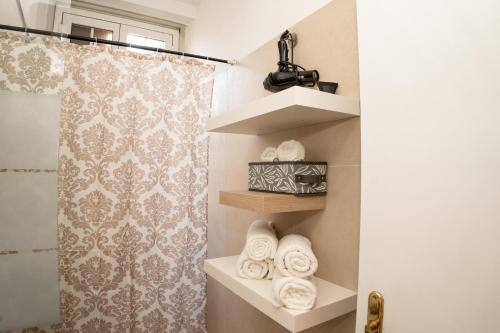 ein Badezimmer mit einer Dusche und Regalen mit Handtüchern in der Unterkunft RoofRhome in Rom