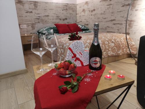 a bottle of wine and a bowl of fruit on a table at City Center Apartments Mostowa 17A in Augustów