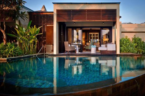 a swimming pool in front of a villa at The Ritz-Carlton Bali in Nusa Dua