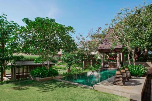 a backyard with a swimming pool and a gazebo at The Ritz-Carlton Bali in Nusa Dua