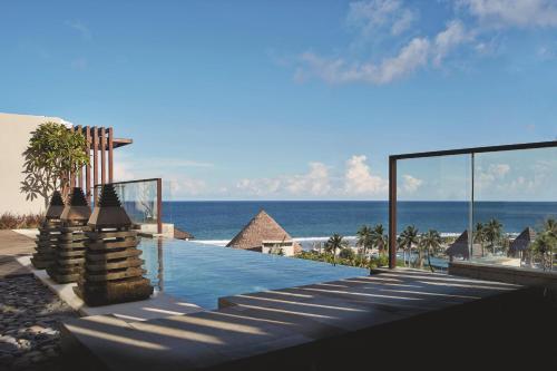 a swimming pool with a view of the ocean at The Ritz-Carlton Bali in Nusa Dua