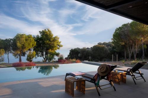 a patio with two chairs and a pool at Theros Estate in Amfilochía