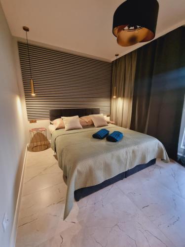 a bedroom with a large bed with two blue towels on it at Apartament Jacuzzi in Kraków