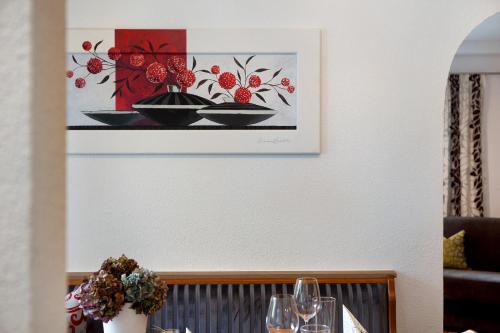 a table with glasses and a picture on the wall at Apart Löffler in Kappl