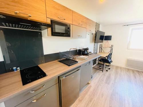 a kitchen with a counter with a microwave and a desk at Studio 4 cosy et tout équipé à la gare de Lorient in Lorient