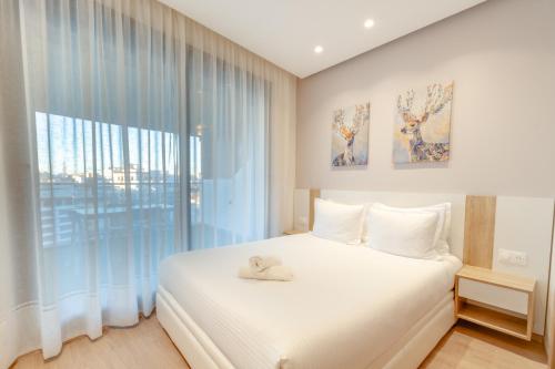 um quarto com uma cama branca e uma grande janela em Luxury Apartments em Tânger