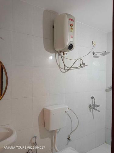 a white bathroom with a toilet and a sink at 2bkh Ahmedabad in Ahmedabad