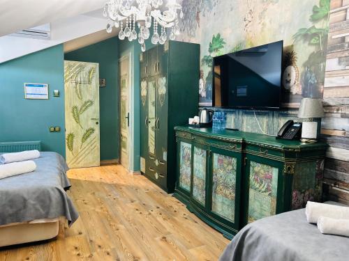 a room with two beds and a television on a wall at Hotel Zerta Old Tbilisi in Tbilisi City