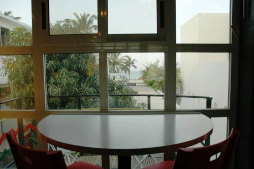 a table and chairs in a room with a window at Villaannadakar in Dakar