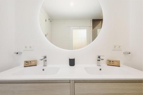 a bathroom with two sinks and a mirror at Luxurious frontline golf apartment in Elviria in Marbella