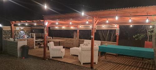 a wooden deck with a ping pong table and lights at Hermosa Cabaña en Colliguay in Cerro Viejo