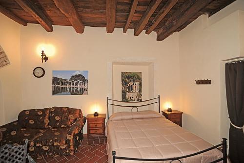 a bedroom with a bed and a couch at Rustico La Rosa in Tivoli