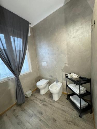 a bathroom with a toilet and a sink and a window at Basiglio Centro Storico in Basiglio