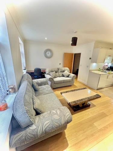 uma sala de estar com dois sofás e uma mesa em Lovely cosy apartment Bromley em Bickley