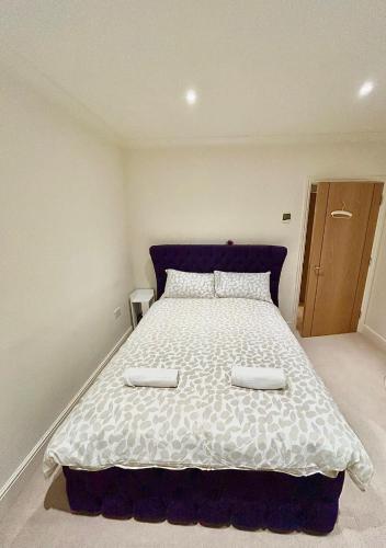 um quarto com uma cama grande e 2 almofadas brancas em Lovely cosy apartment Bromley em Bickley