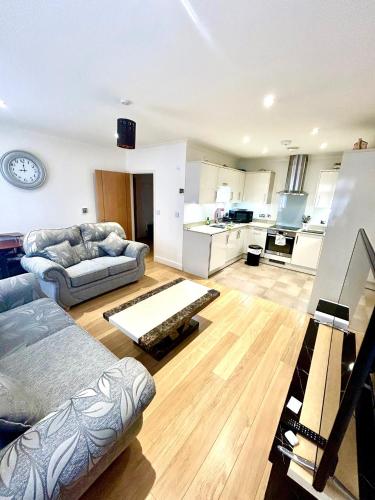 a living room with two couches and a kitchen at Lovely cosy apartment Bromley in Bickley