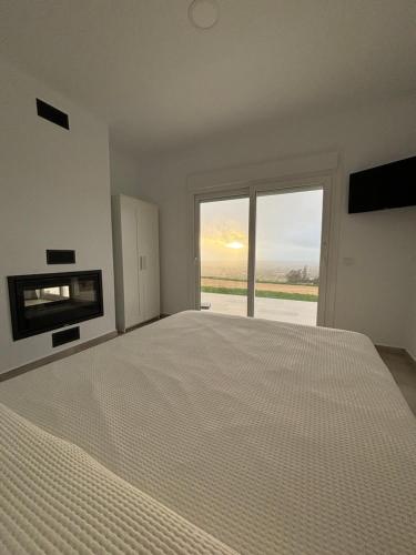 ein Schlafzimmer mit einem großen Bett und einem großen Fenster in der Unterkunft Mirador el atardecer in Cádiz