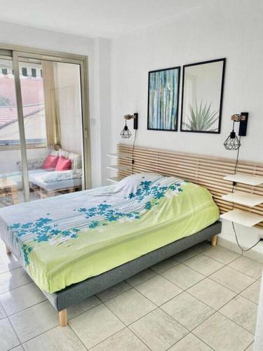 - une chambre avec un lit orné de fleurs bleues dans l'établissement Le Central Spacieux avec loggia, à Saint-Raphaël