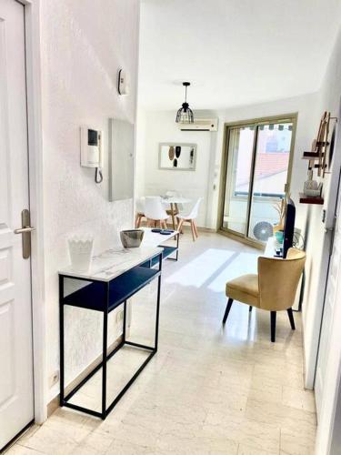 une pièce avec une table et des chaises dans une pièce dans l'établissement Le Central Spacieux avec loggia, à Saint-Raphaël