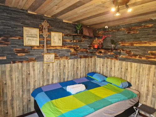 Hunters little house في Gardur: غرفة نوم بسرير مع جدار خشبي