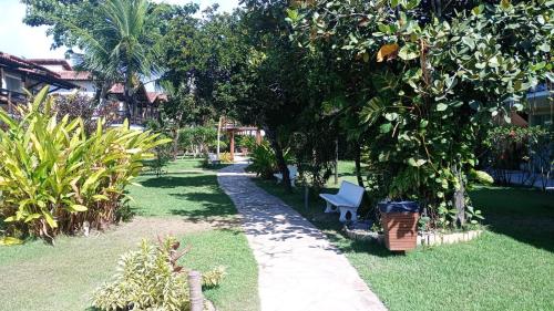 a garden with a blue chair under a tree at Village Muta in Porto Seguro