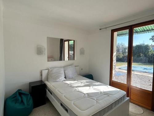 uma cama branca num quarto com uma janela em Maison Elne, 5 pièces, 10 personnes - FR-1-732-60 em Elne