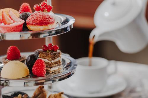 a three tiered plate of desserts on a table at The Arkin Colony Hotel in Kérynia