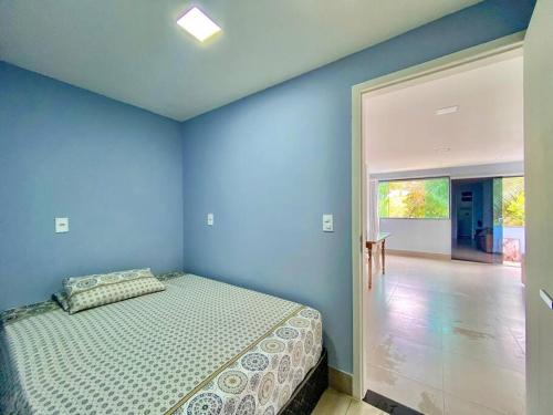 a bedroom with a bed with a blue wall at Beira Mar Meaipe Apt 1Q c/ lazer in Guarapari