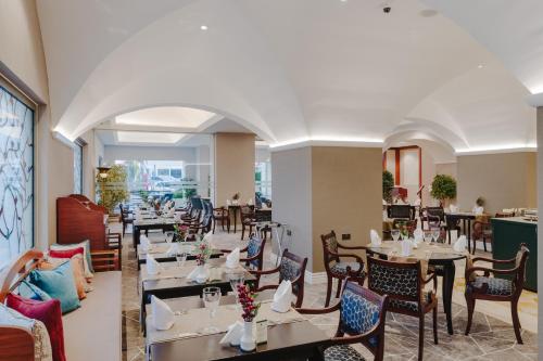 a restaurant with tables and chairs in a room at The Arkin Colony Hotel in Kérynia