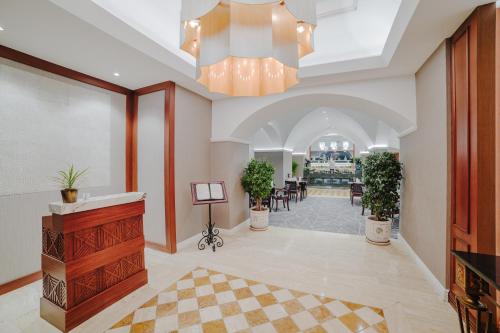 a lobby with a chandelier and a dining room at The Arkin Colony Hotel in Kérynia