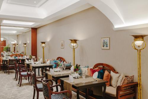 a dining room with tables and chairs and a room with at The Arkin Colony Hotel in Kérynia