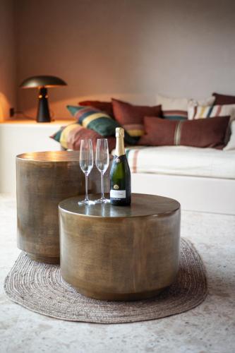 a bottle of champagne and two wine glasses on a table at B'Guest Sleep & Retreat in Bruges