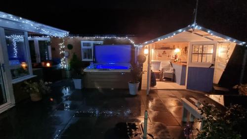 a house with christmas lights on a patio at night at Dungarvon House B&B, Luxury, Garden Hot Tub, Private Summerhouse, EV Point , 3x Bedroom Options in Weston-super-Mare