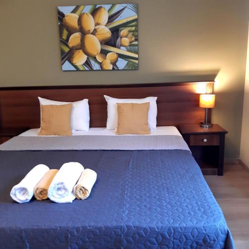 a bedroom with a blue bed with towels on it at Villa Di Poletta in Dobrich