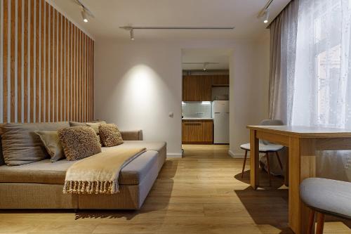 una sala de estar con un sofá y una mesa en Feel Lviv! Old City Apartment, en Leópolis