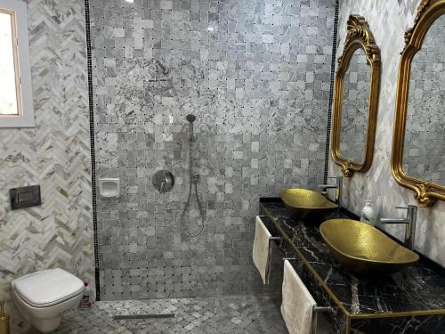 ein Bad mit 2 Waschbecken und einer Dusche in der Unterkunft Villa Olympus - Monastir 