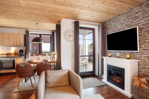a living room with a fireplace and a tv at Bergchalet 20 in Diemelsee