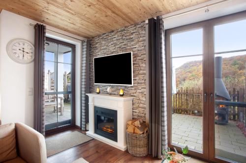 sala de estar con chimenea y TV de pantalla plana en Bergchalet 20, en Diemelsee