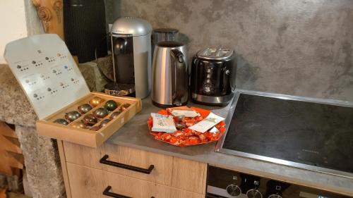 a counter with a coffee maker and a box of food at Petit chalet rustique et bucolique in Bovernier
