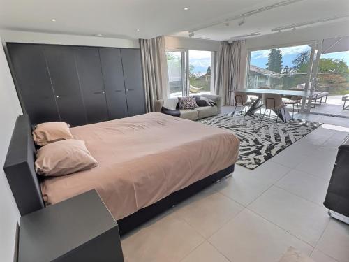 a bedroom with a large bed and a dining room at Attica Résidences, Lausanne in Saint-Sulpice