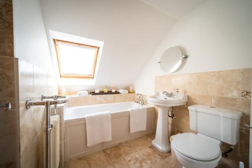 a bathroom with a tub and a toilet and a sink at Nether Glenny Farm in Stirling