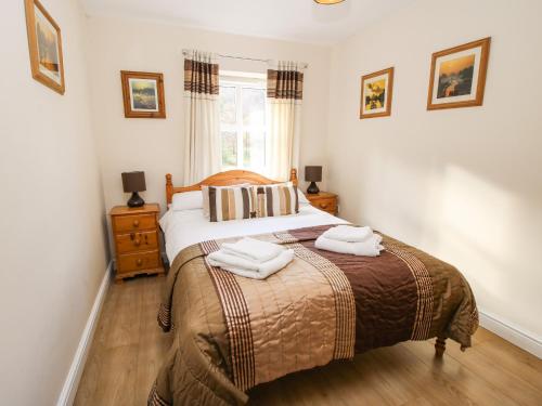 a bedroom with a bed with two towels on it at Alyn View in Llanferres