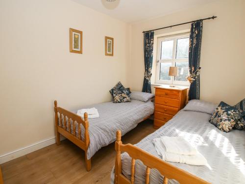 a bedroom with two twin beds and a window at Alyn View in Llanferres